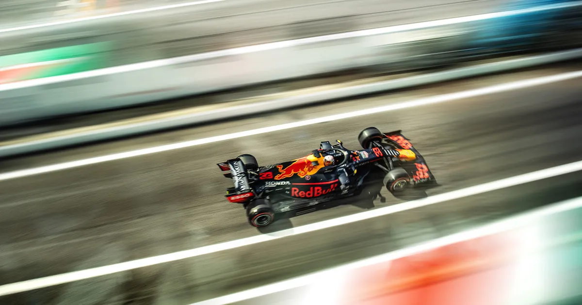 A motion blurred Red Bull Racing F1 car on a straight