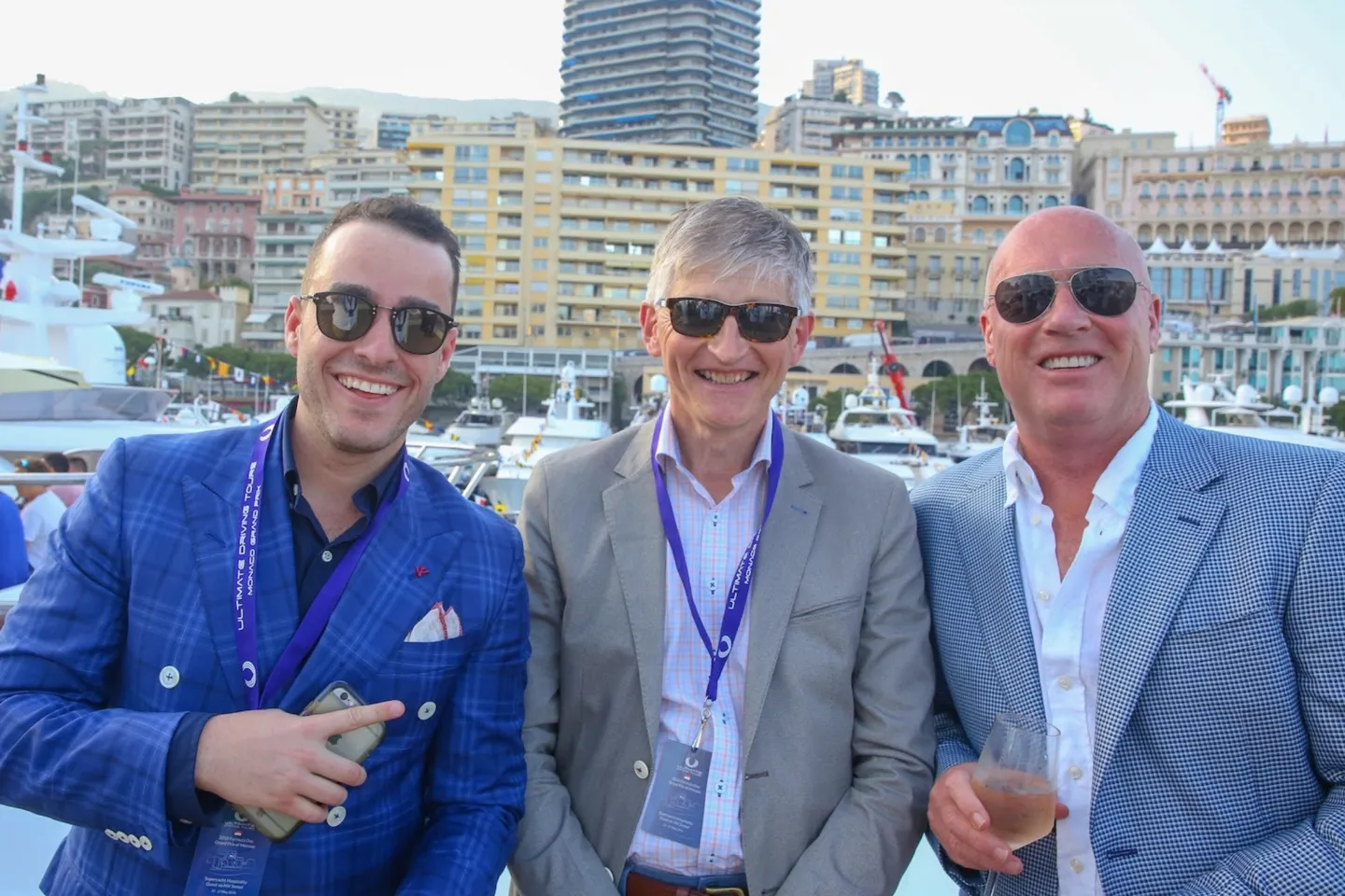 three men wearing suit jackets and sunglasses at the Monaco Grand Prix