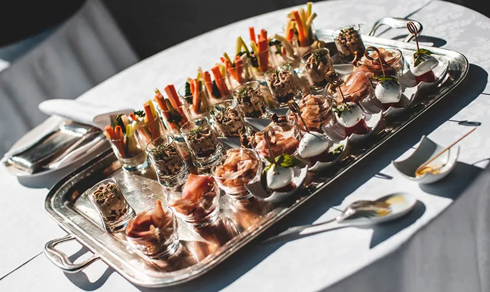 A silver platter holds delicate canapés in decorative glasses ready for serving to Ultimate Driving Tours&rsquo;; guests in Italy