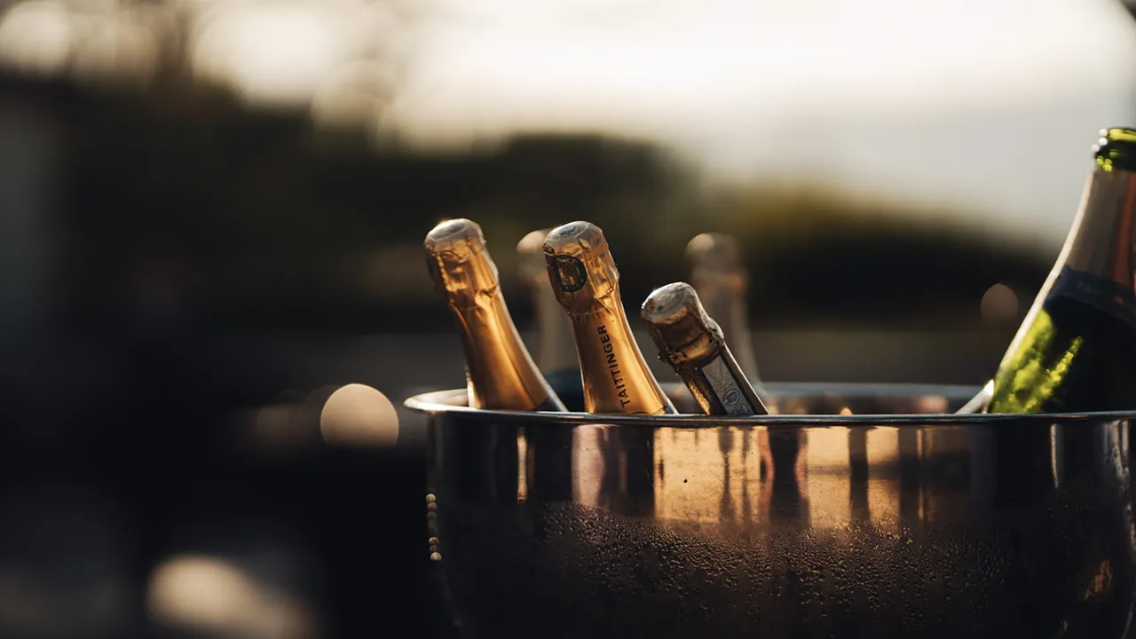 Champagne bottle necks poke above the rim of a stylish metal ice bucket