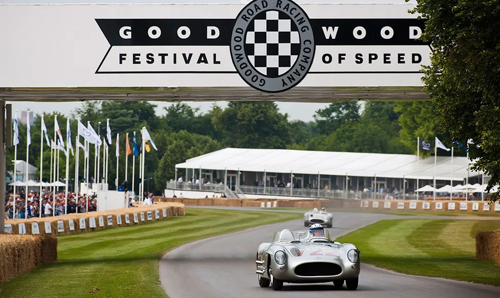 A classic racing car climbing the hill at the iconic Goodwood race track for the Festival of Speed