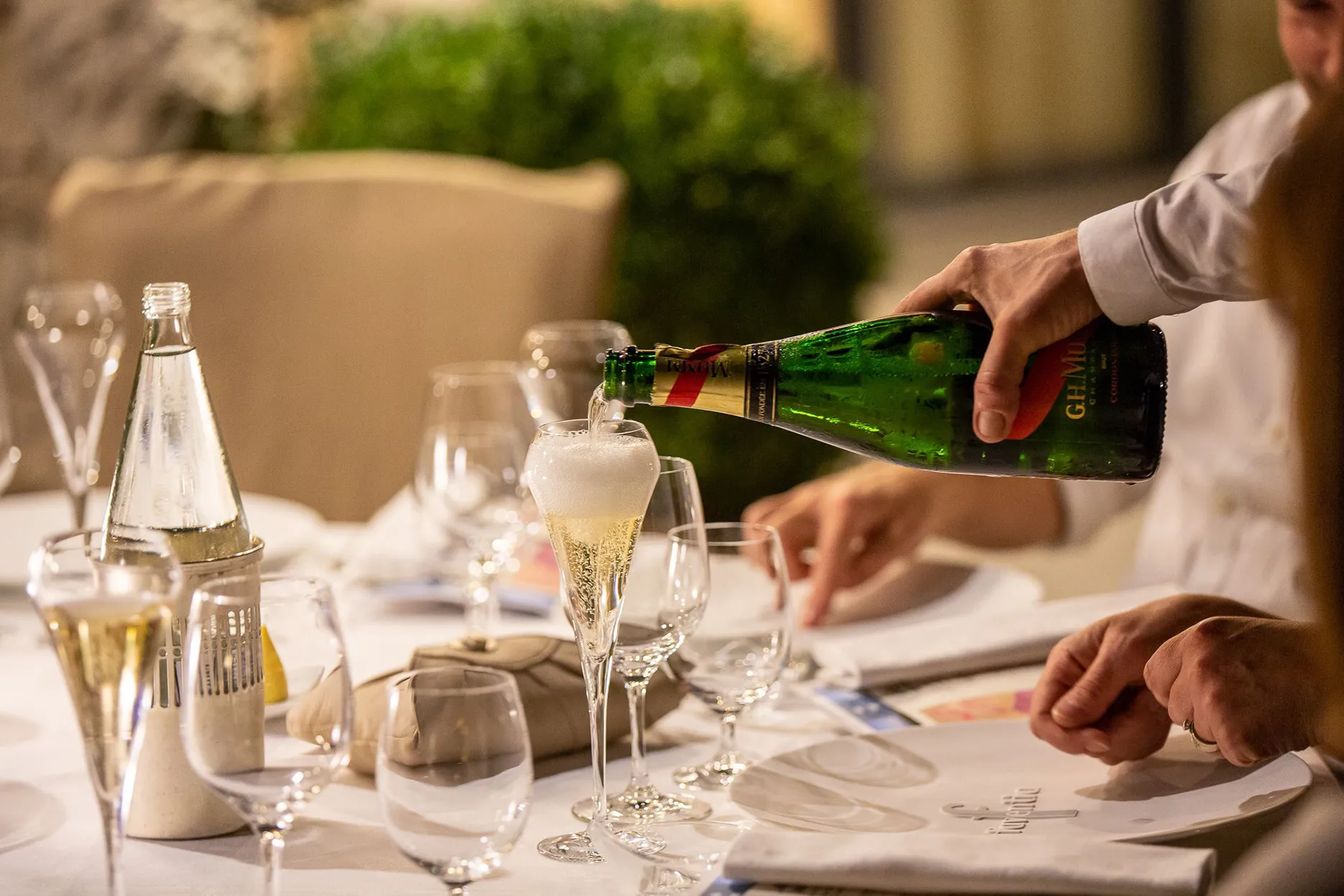 A waiter pours champagne in a fine dining restaurant in France