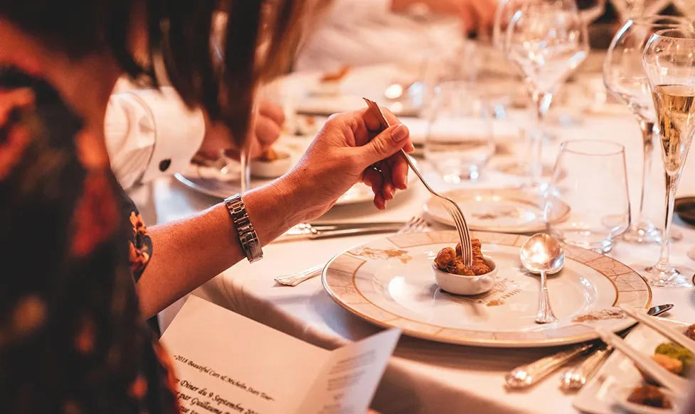 A woman dines on a delicate dish in a classy French restaurant