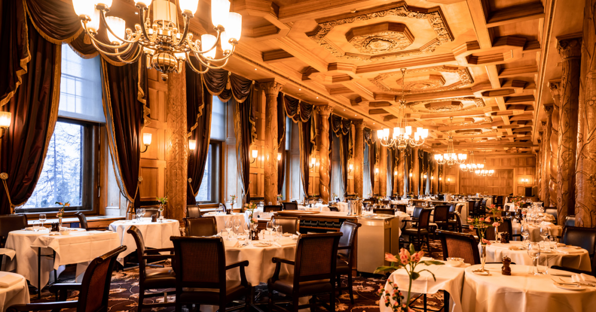 The dining room at the Grand Restaurant, Suvretta House lit by chandeliers.