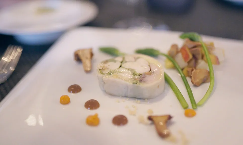 An elegant plate of food holds flavoured gels and pate with micro greens