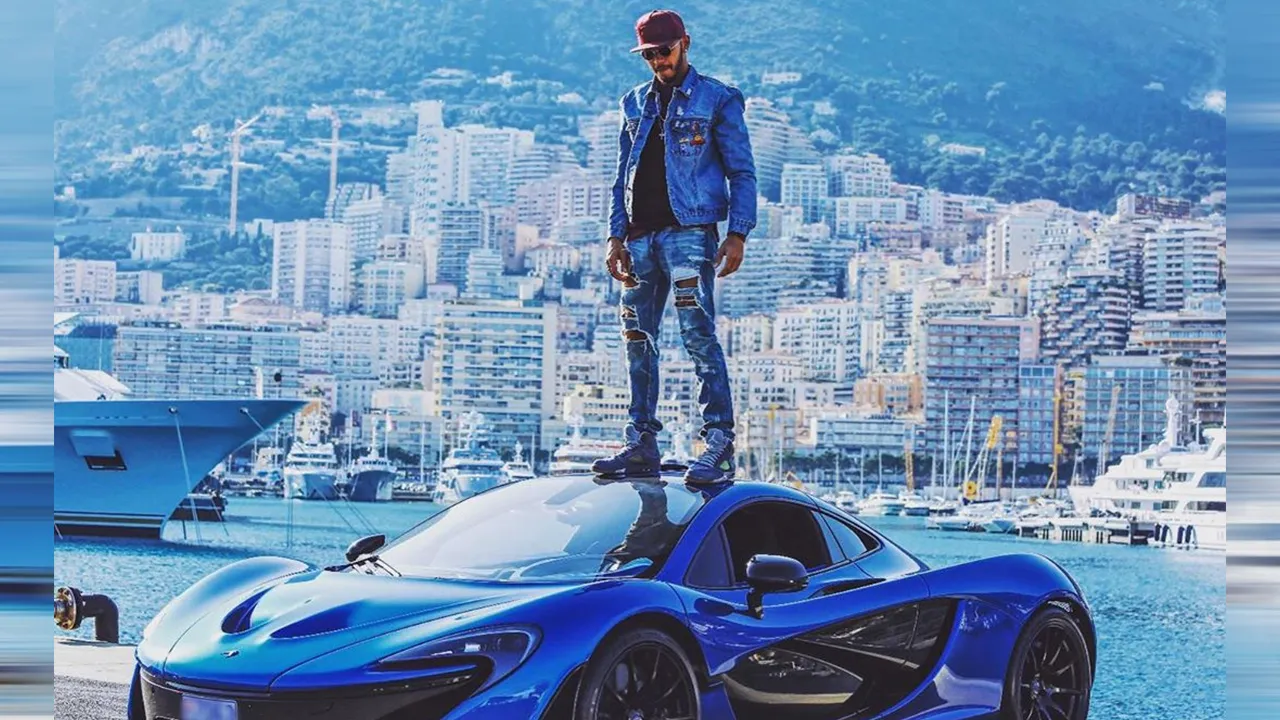 Formula One driver Lew Hamilton standing on top of his supercar with a view of Monaco behind him