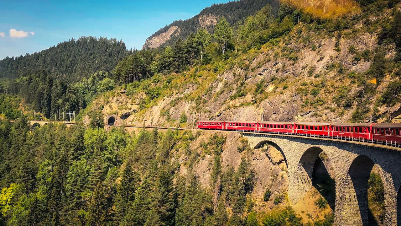 The Bernina Express crossing an elevated bridge in the mountain