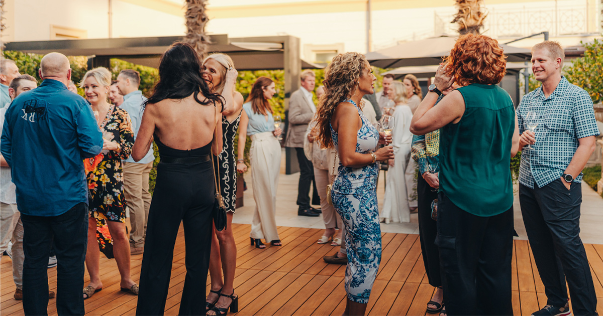 Tour guests socialising in snappy outfits in an al fresco setting
