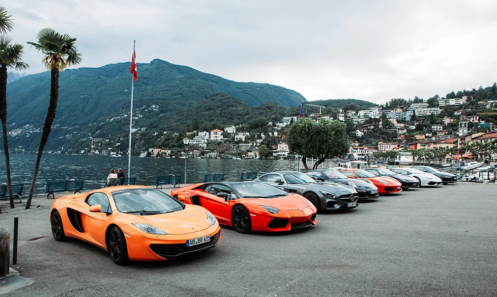 Ultimate Driving Tours’ fleet of supercars sitting by the waterfront in Switzerland