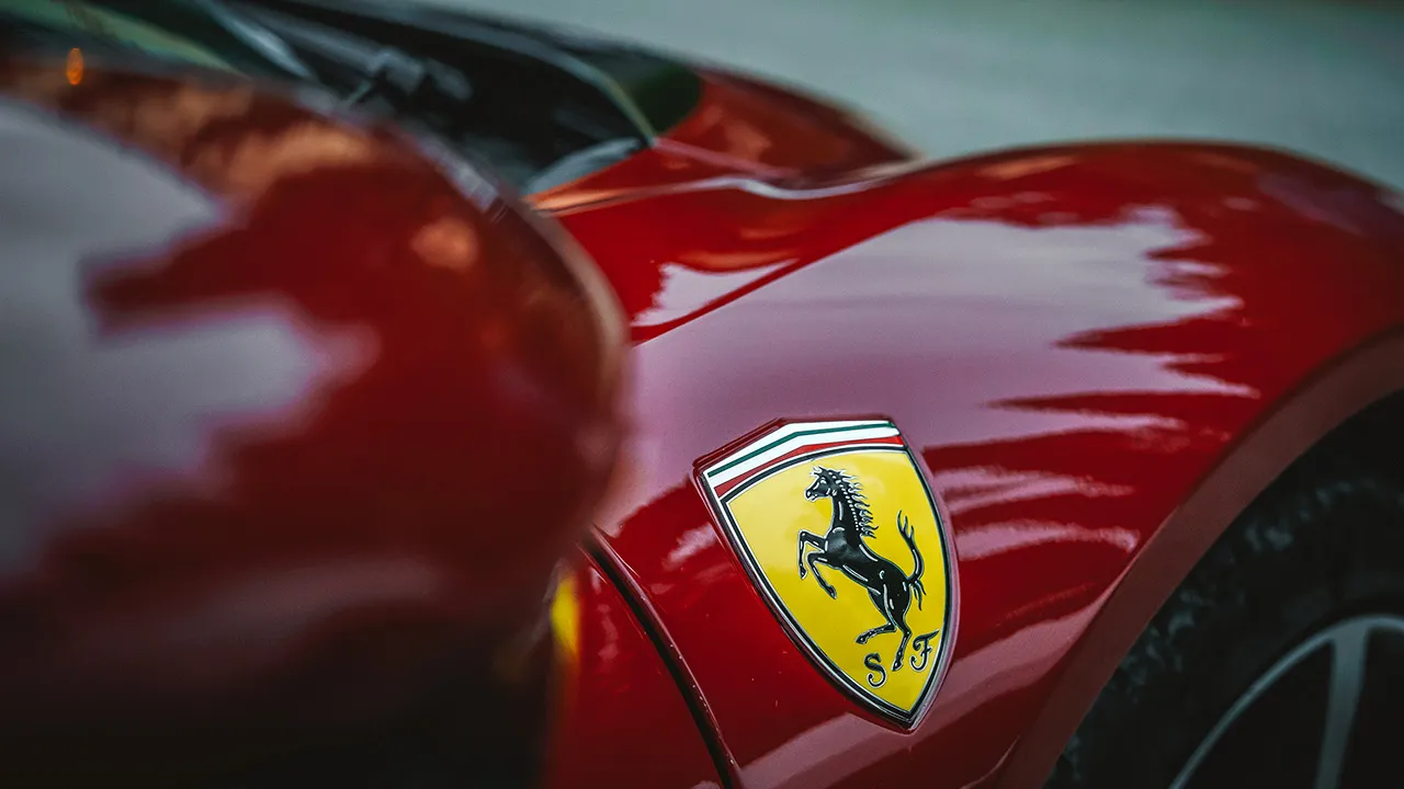 A close up of a Ferrari badge on the flank of a red car