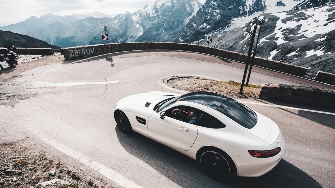 Taking a sharp turn on Stelvio Pass, Italy in one of the Ultimate Driving Tours supercars