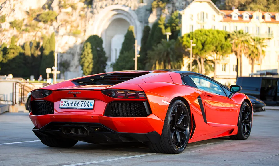 A red Lamborghini Aventador is seen from the rear as it drives through Monaco on an Ultimate Driving Tours luxury holiday