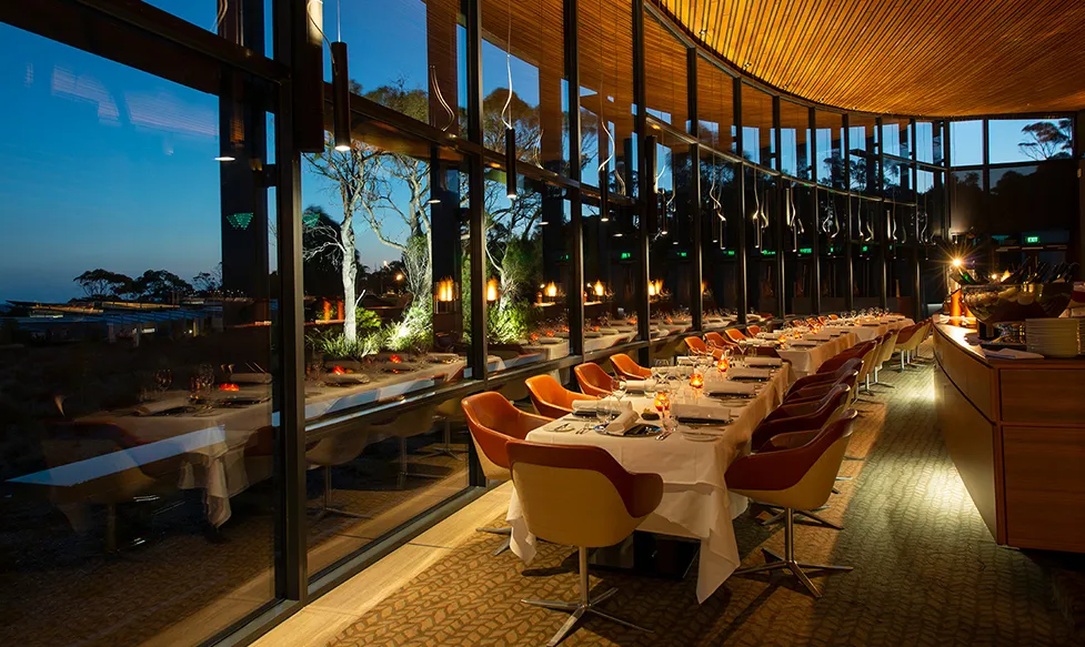 Elegant lighting illuminates a large dining room with panoramic views at Saffire Freycinet resort, Australia