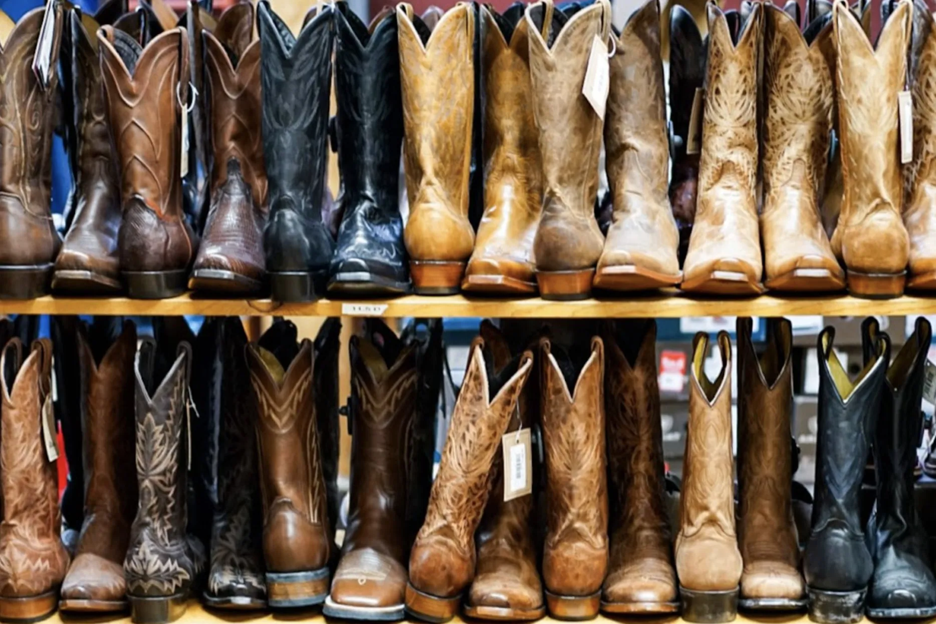 A wooden rack full of traditional cowboy boots
